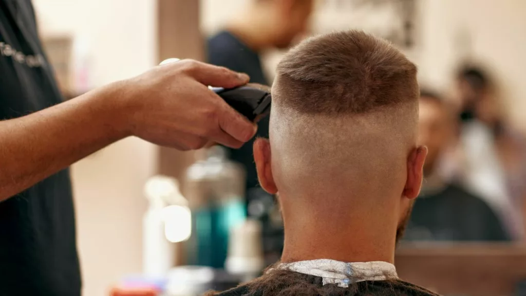 Barbero recortando el pelo de una persona para darle estilo.