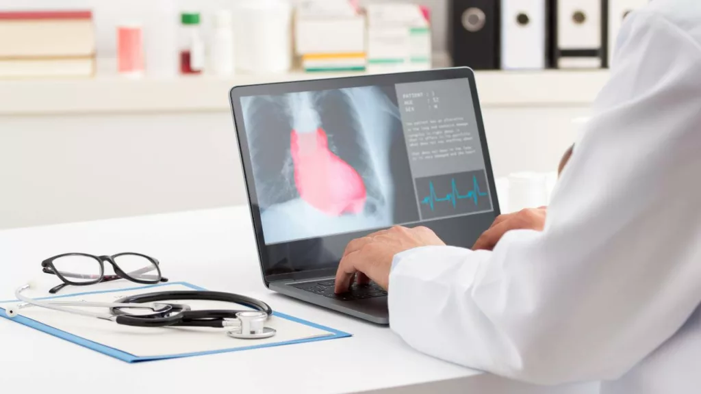 Cardiólogo estudiando desde su laptop el escaneo de un corazón, de su paciente.