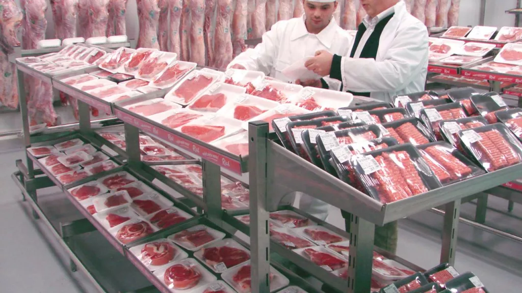 Personal de carnicería empaquetando carne para vender.