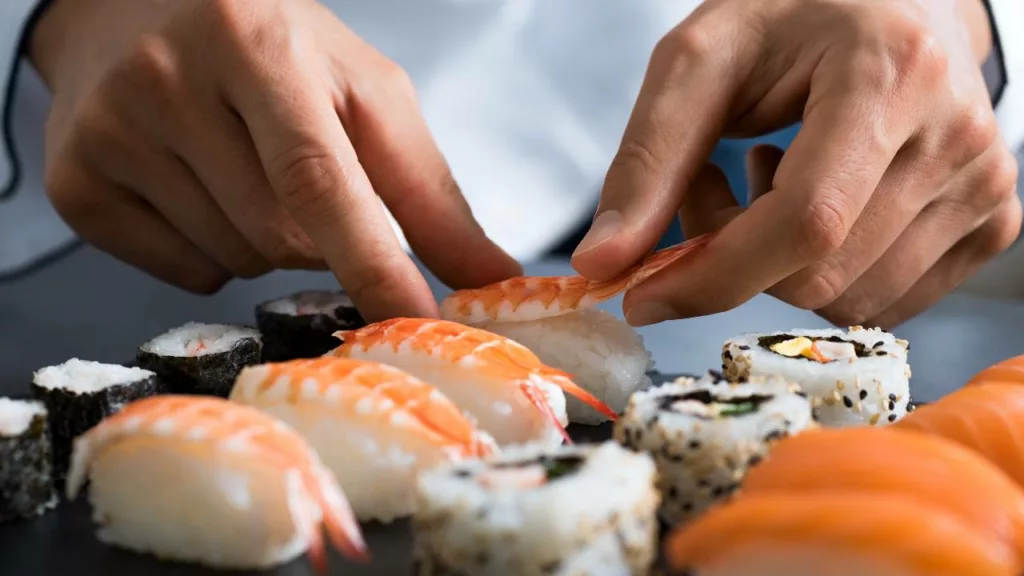 Chef prepara sushi para sus clientes en un restaurante.