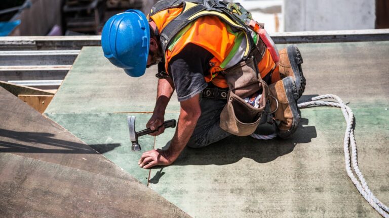 Albañil trabajando en una construcción con un martillo.