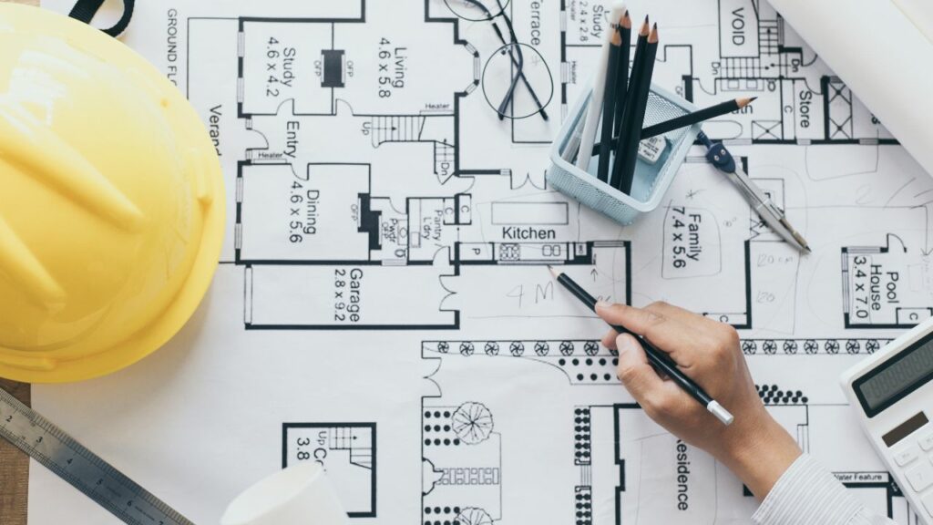 Arquitecto trabajando en sus planos con un lapiz