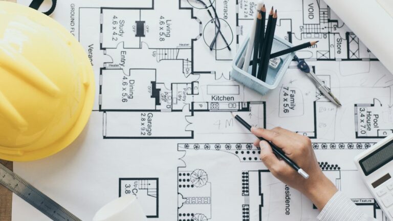 Arquitecto trabajando en sus planos con un lapiz
