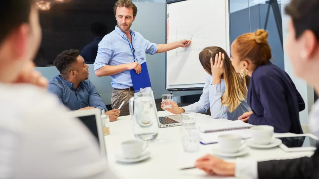 Asesor orientando a un equipo de trabajo de un negocio.