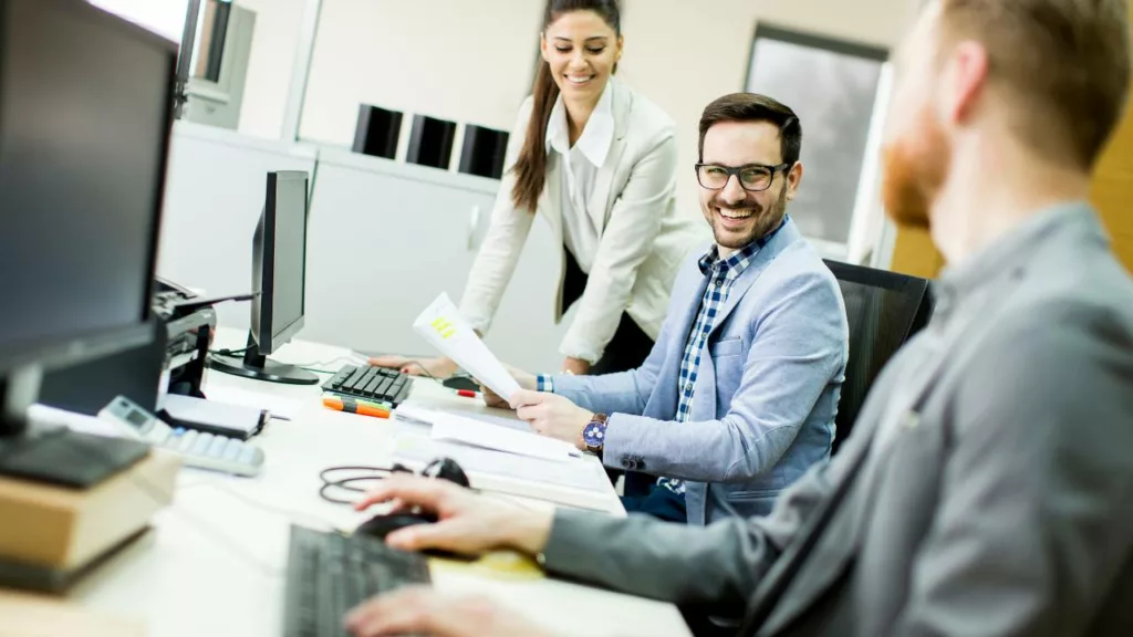 Compañeros asistiendo en el trabajo a su jefe.
