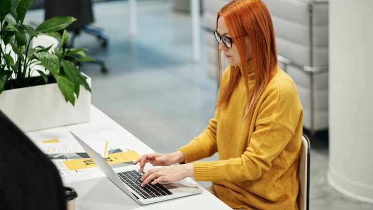 Mujer que trabaja en su laptop como auxiliar