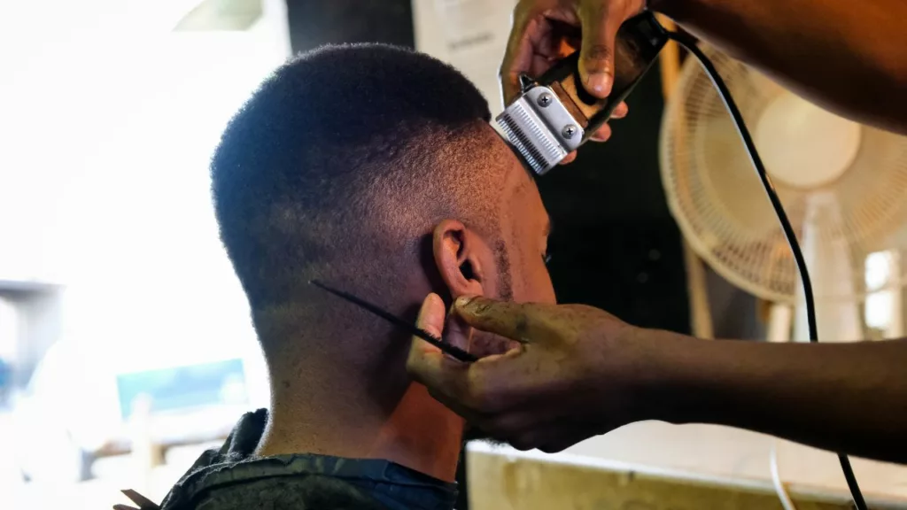 Barbero recortando el pelo a un cliente.