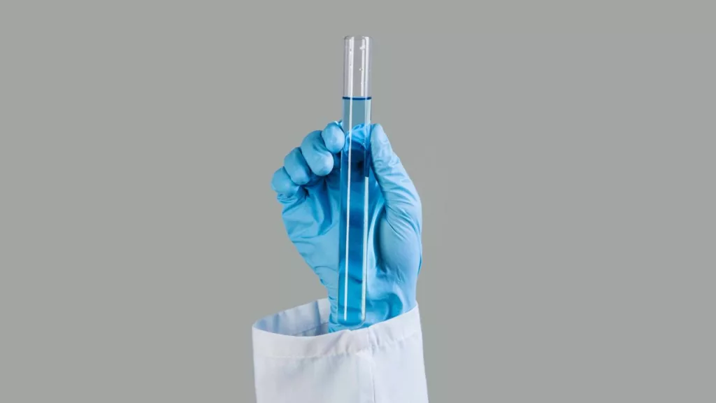 Bioanalista sosteniendo una muestra química.