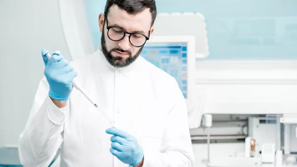 Bioanalista usando herramientas de laboratorio para analizar muestras médicas.