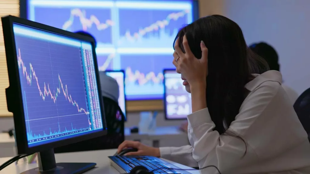 Agente de bolsa de valores revisando la caída de valor de un activo financiero.