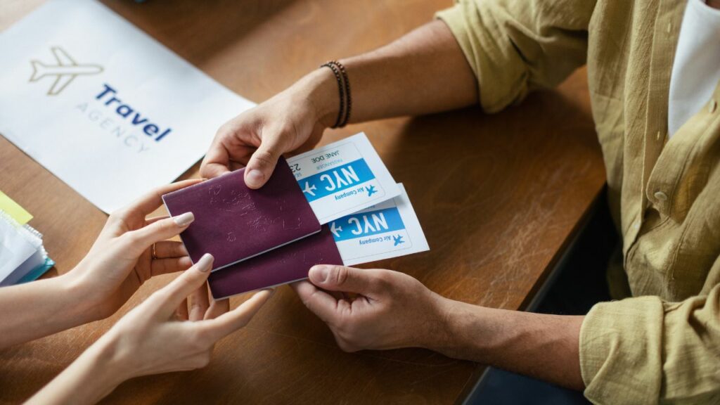 Agente de viajes le entrega pasaporte y boleta de avión a su cliente.