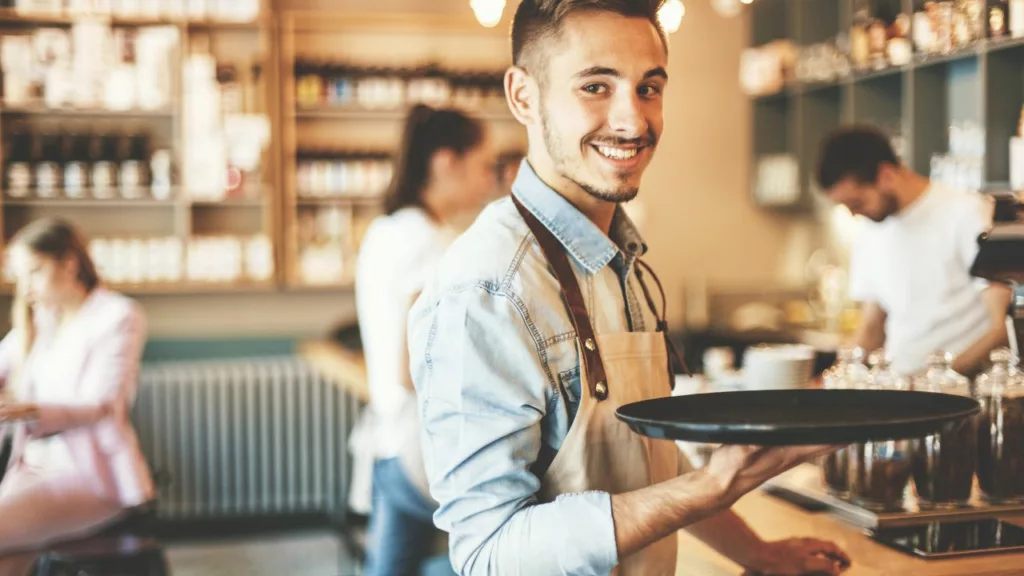 Joven camarero trabajando en una cafetería