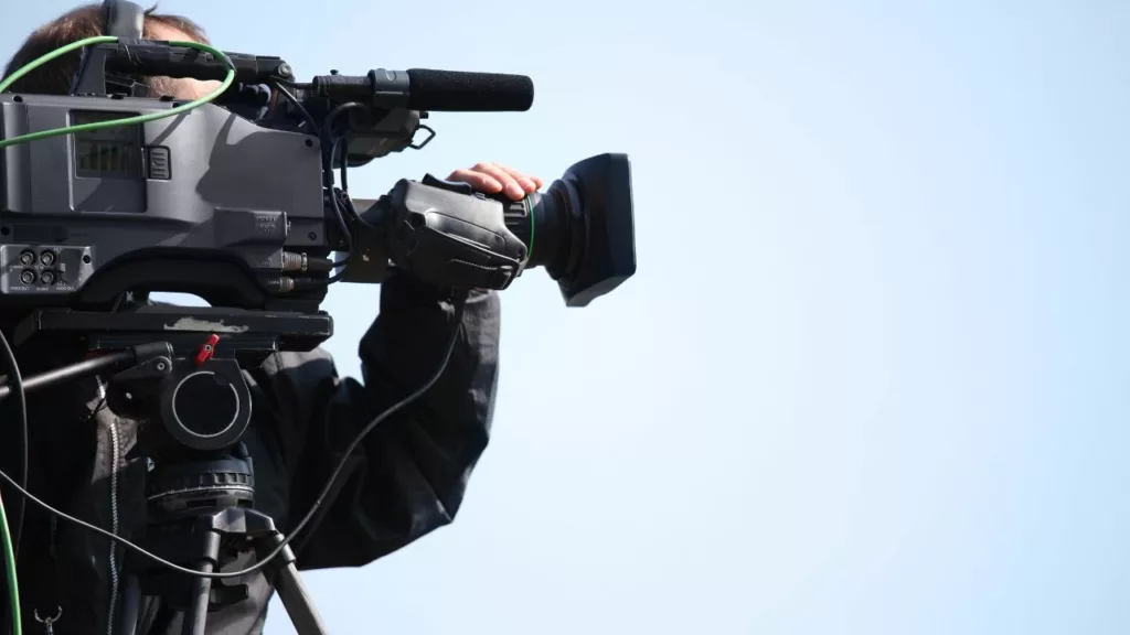Camarógrafo preparando una escena para transmitir una noticia en vivo.