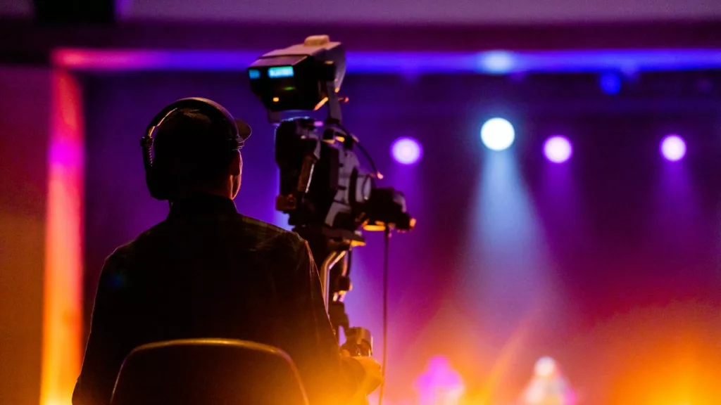 Camarógrafo grabando un concierto de música.