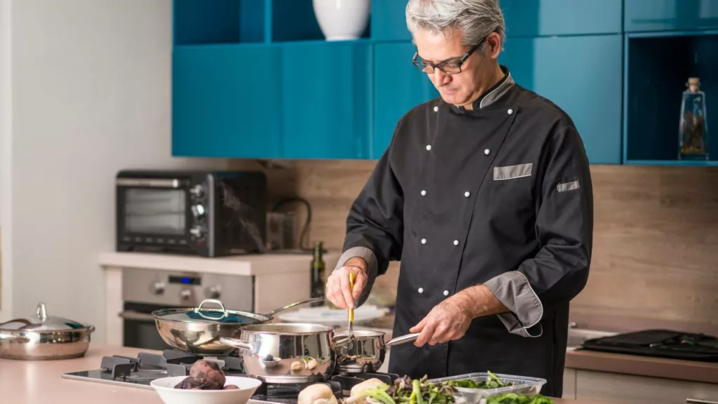 Chef con vestimenta negra, está cocinando para un restaurante.