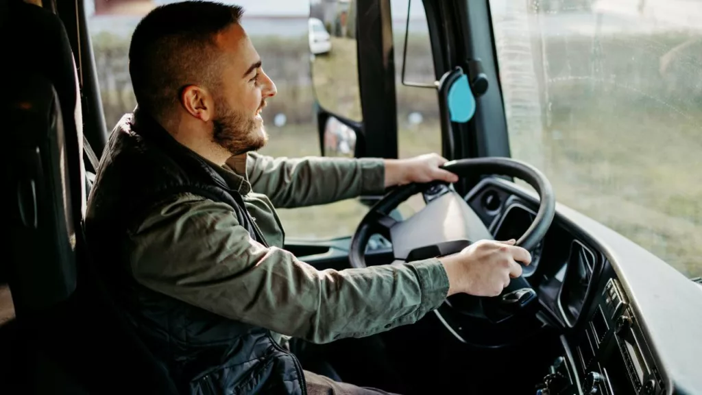 Conductor manejando un truck para llevar productos a una empresa.
